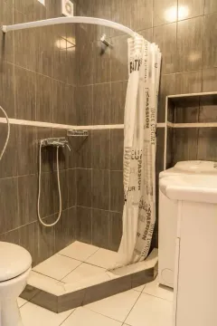 Kupatilo sa tuš kabinom, sivim pločicama i lavaboom. - image 48