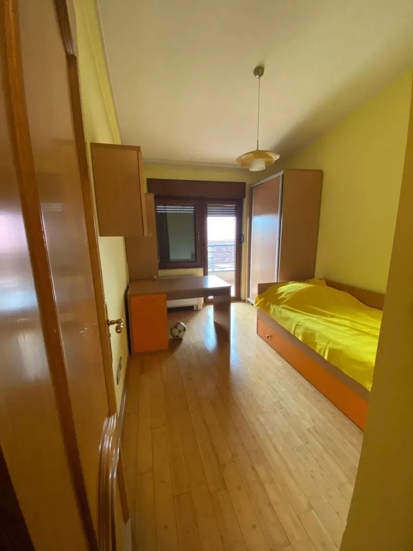 Dječija soba sa krevetom, radnim stolom i ormarom.