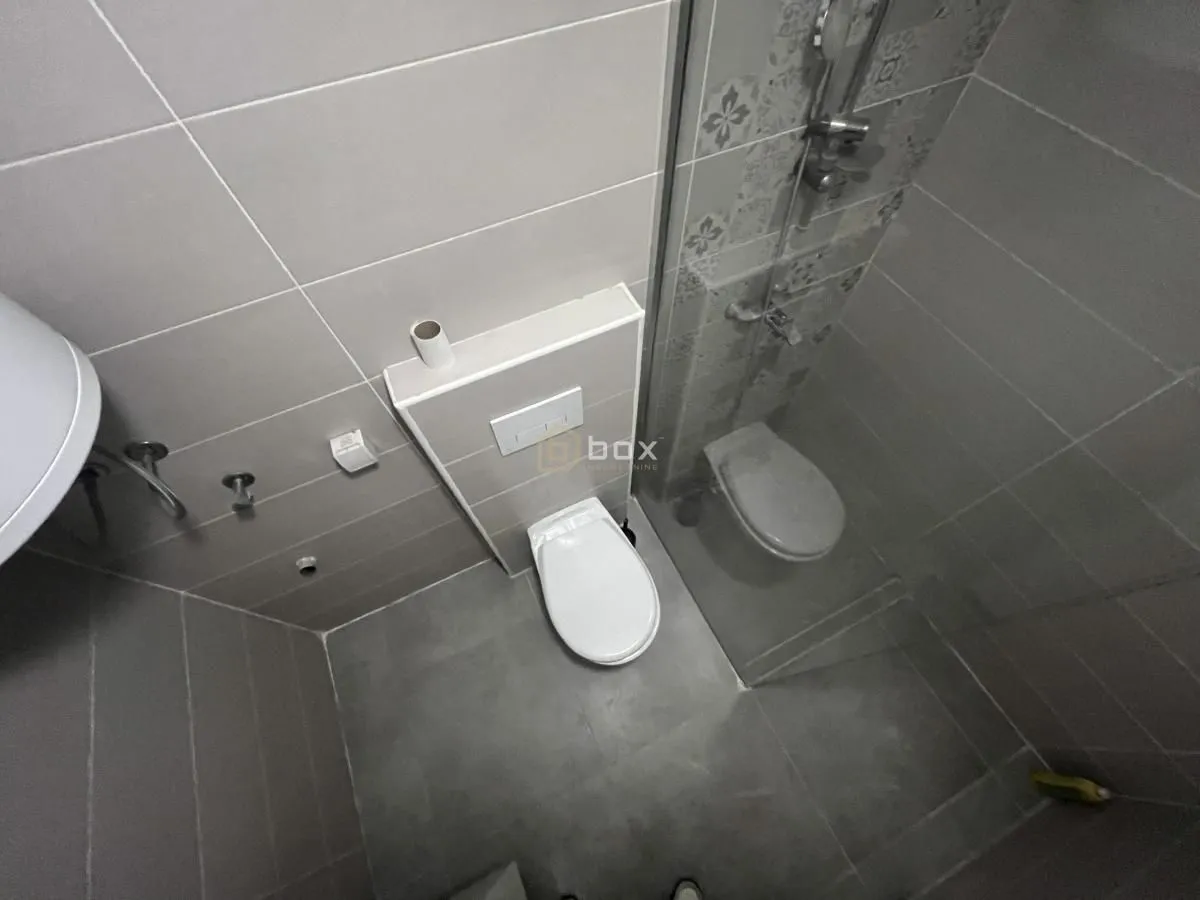 High-angle view of the bathroom with a toilet and a shower cabin.