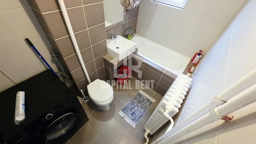 Bathroom equipped with a bathtub, washbasin, toilet, and washing machine.