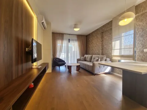 Living room with a sofa, TV, and dining table. - image 2