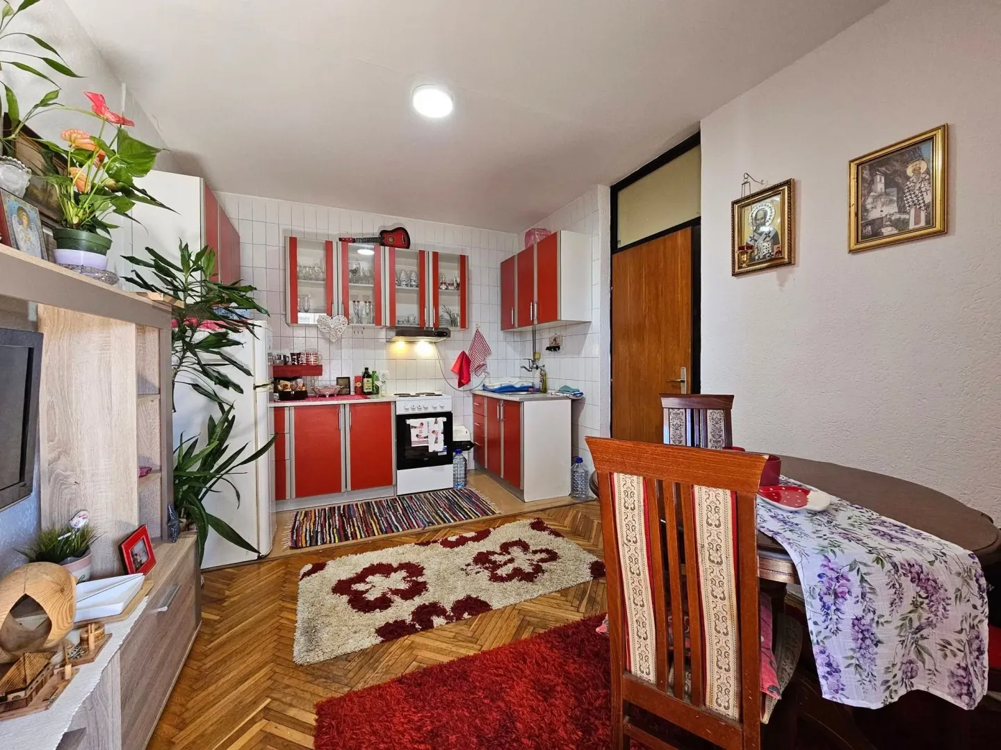Small kitchen with a dining area and parquet flooring.