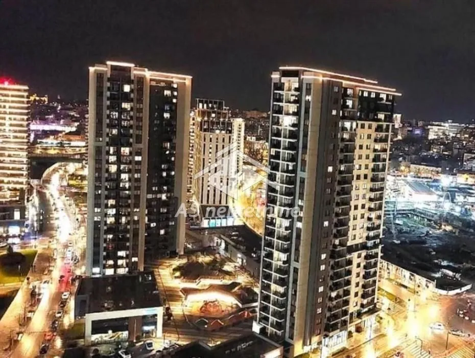 Night view of illuminated modern residential buildings and the surrounding city.
