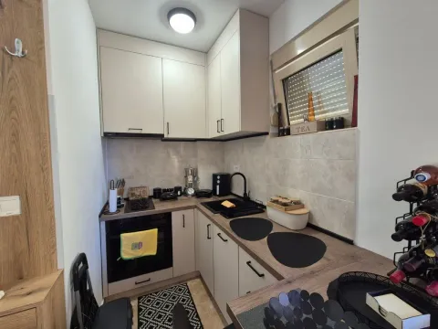 Manja moderna kuhinja sa bijelim elementima i drvenom radnom pločom. - image 7