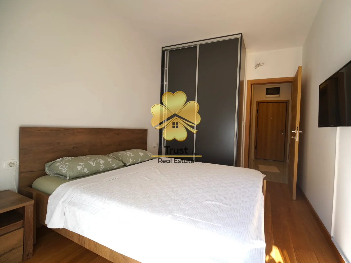 Furnished bedroom with a double bed, wardrobe, and TV.