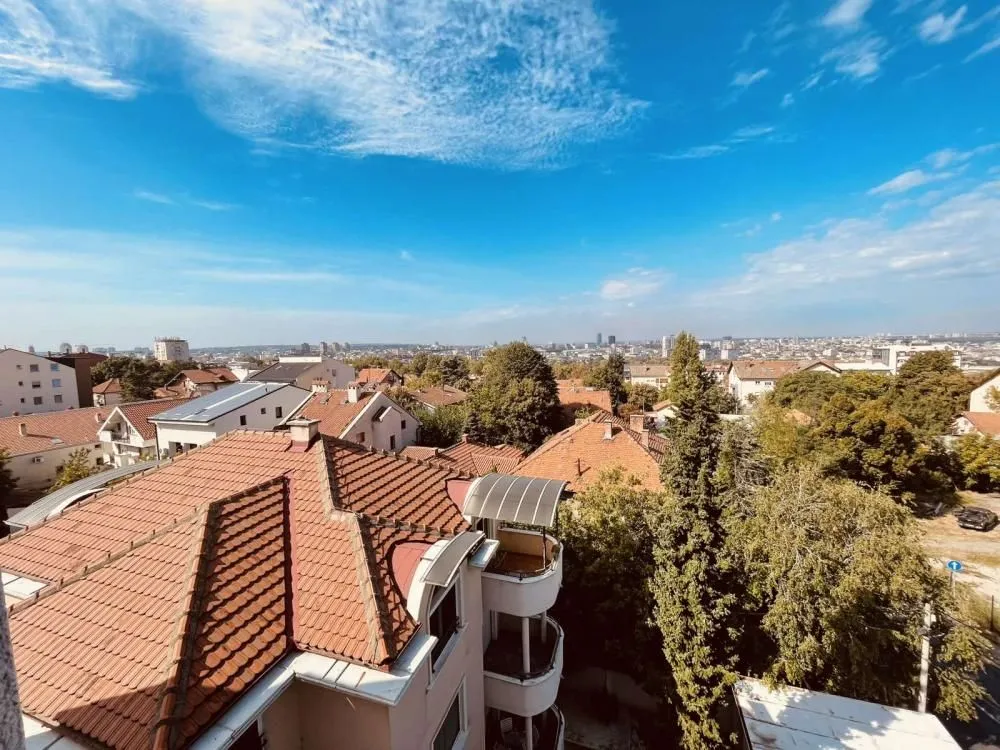 Pogled sa terase na krovove zgrada i okolno naselje.
