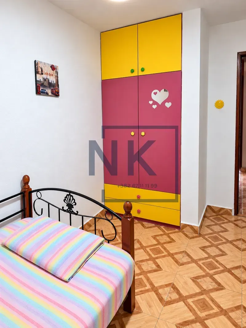 Children's bedroom with a bed and a colorful wardrobe.