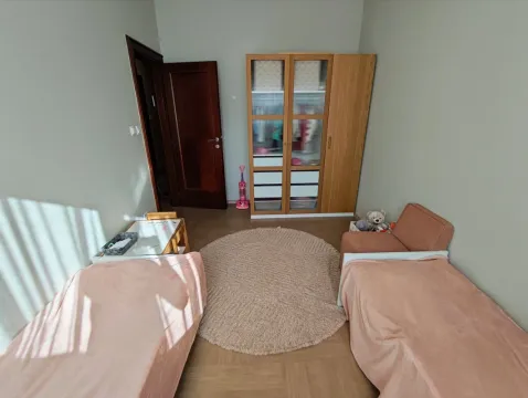 Children's bedroom with two beds, a wardrobe, and a round rug. - image 6