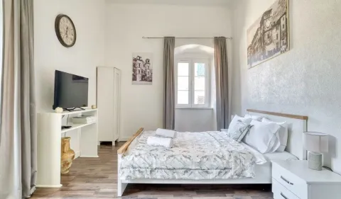 Svjetla spavaća soba sa bračnim krevetom, televizorom i prozorom. - image 13