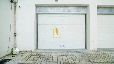 Pogled na bela garažna vrata sa popločanim dvorištem ispred. - image 32