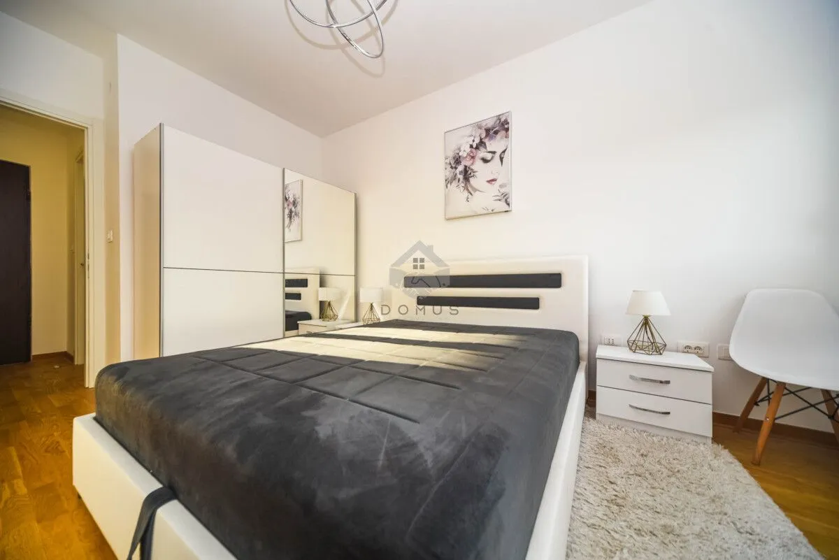 Furnished bedroom with a double bed, wardrobe, and a nightstand.