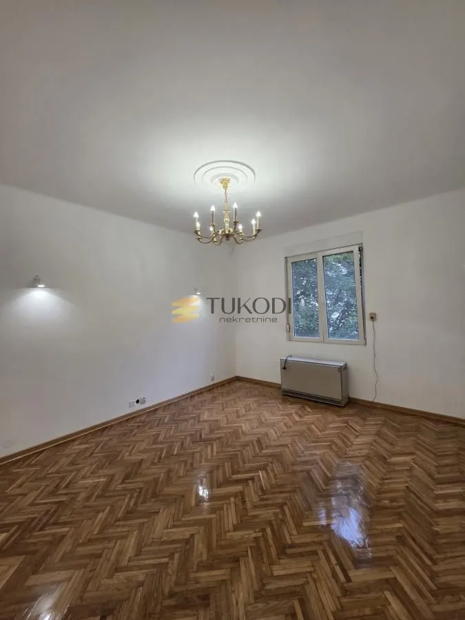 Empty room with parquet flooring and a window.