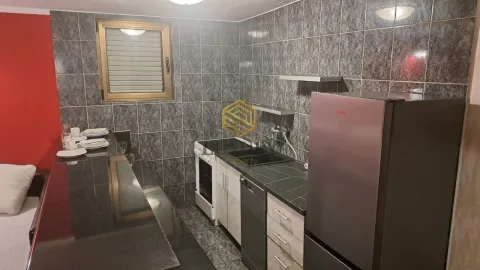 Manja opremljena kuhinja sa šankom i sivim keramičkim pločicama. - image 8