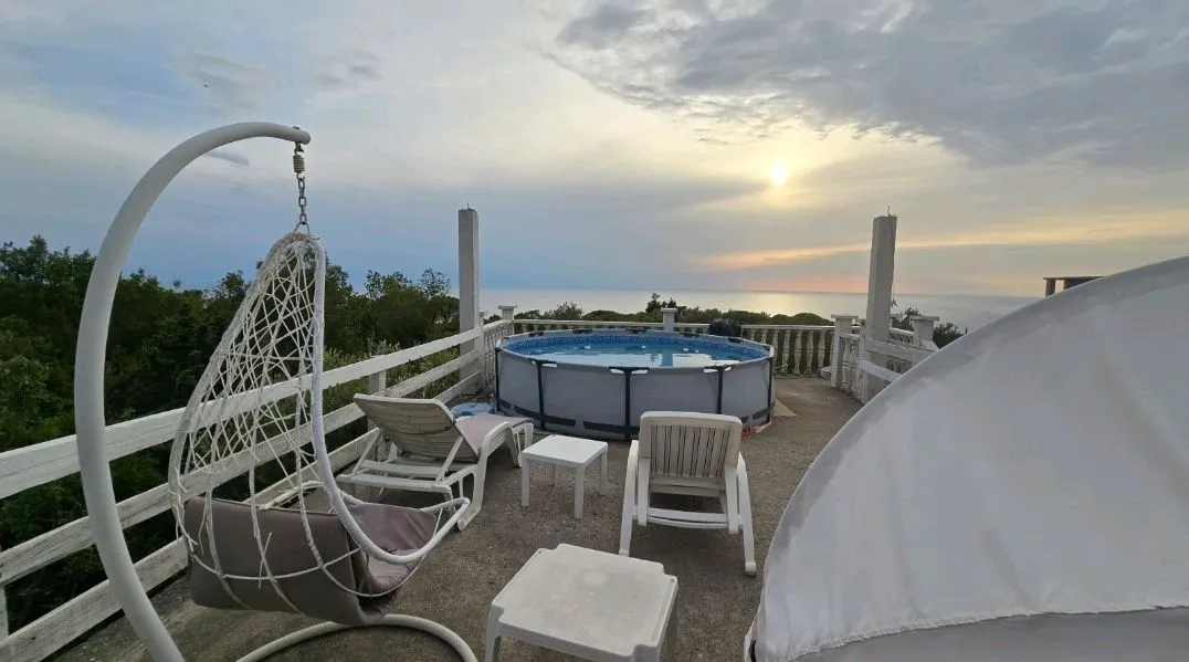 Roof terrace with a pool, loungers, and a sea view.