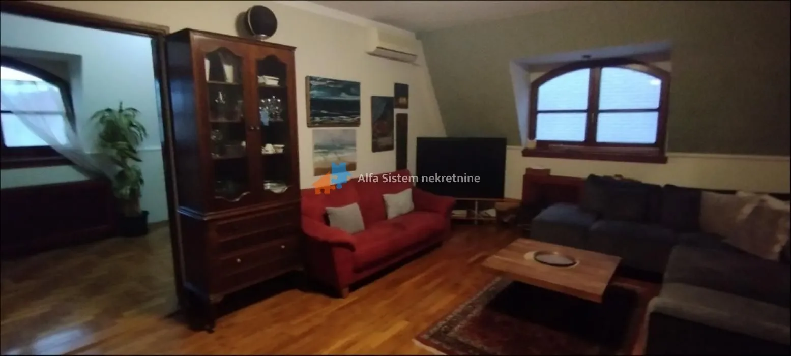 Living room with sofa set, TV, and wooden furniture.
