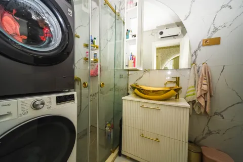 Savremeno opremljeno kupatilo sa zlatnim umivaonikom i veš-mašinom. - image 13