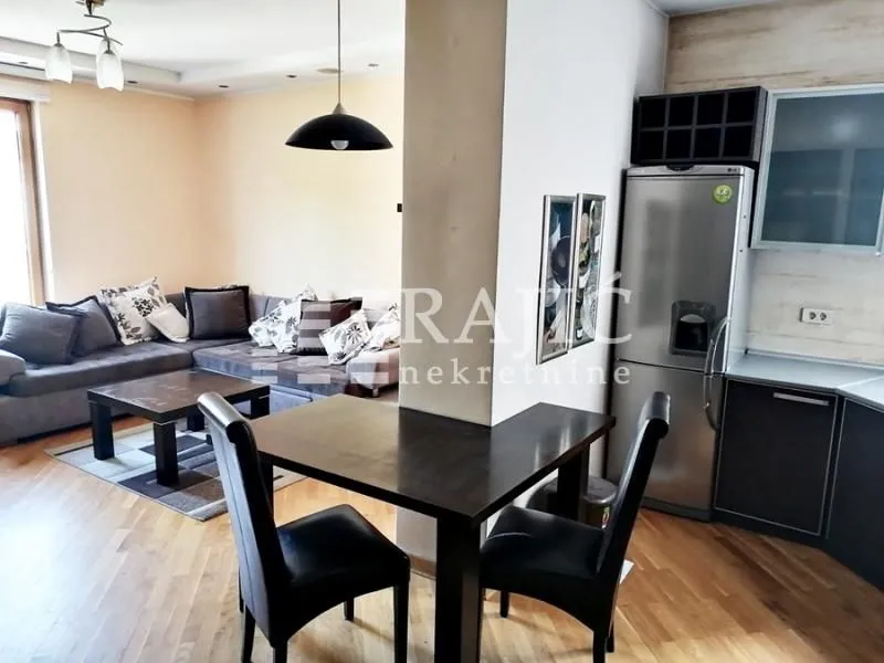 Living room with dining area and kitchen in light tones.