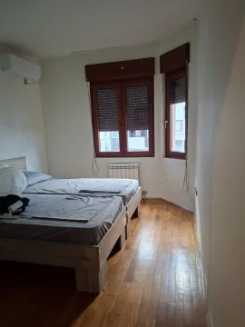 Bedroom with a double bed, wooden flooring, and windows with shutters. - image 12
