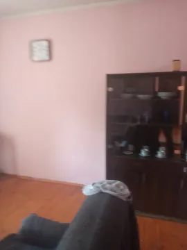 Soba sa drvenom vitrinom, zidnim satom i dijelom kauča. - image 4