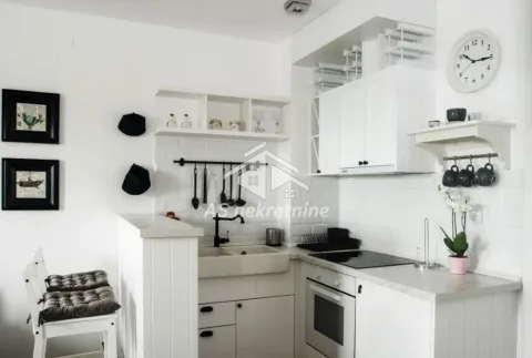 White kitchen with a sink, built-in oven, and a breakfast bar. - image 10