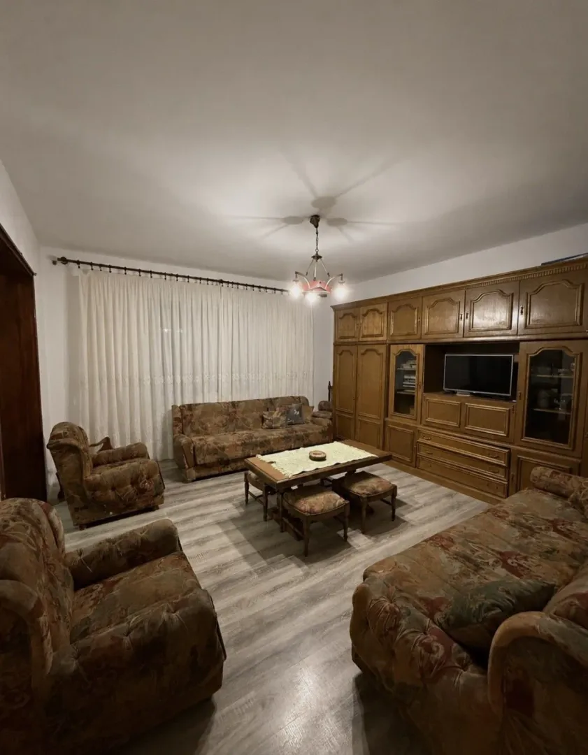 Living room with a seating set and a large wooden wardrobe.