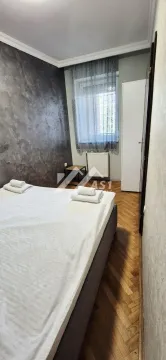 Spavaća soba sa bračnim krevetom, parketom i prozorom. - image 6