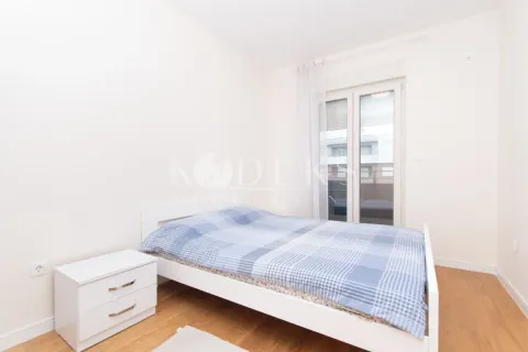 Svjetla spavaća soba sa bračnim krevetom, bijelim noćnim stočićem i izlazom na terasu. - image 7