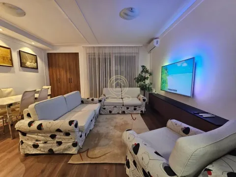 Living room with a sofa set, TV, and a dining area in the background. - image 7