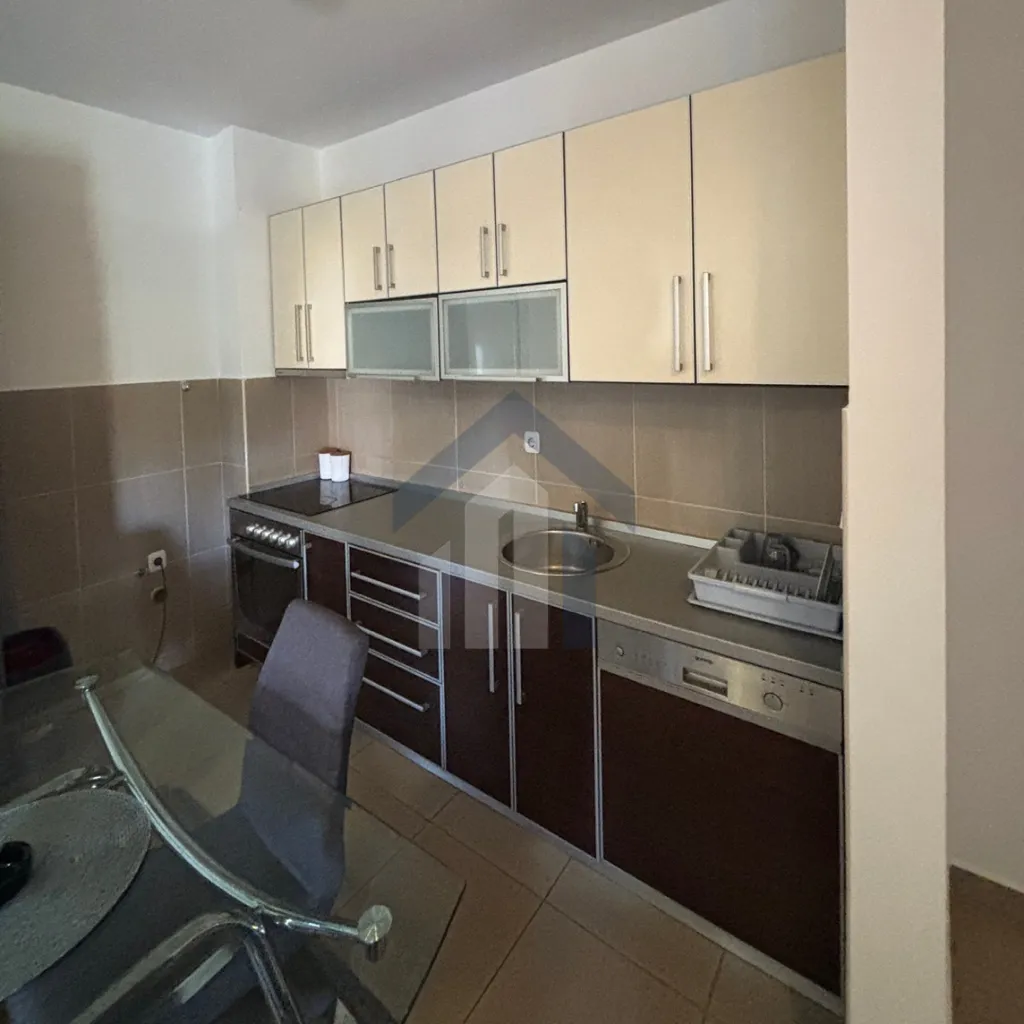 Kitchen with brown and cream cabinetry and a dining table.