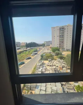 Pogled kroz prozor na okolne zgrade i ulicu. - image 10