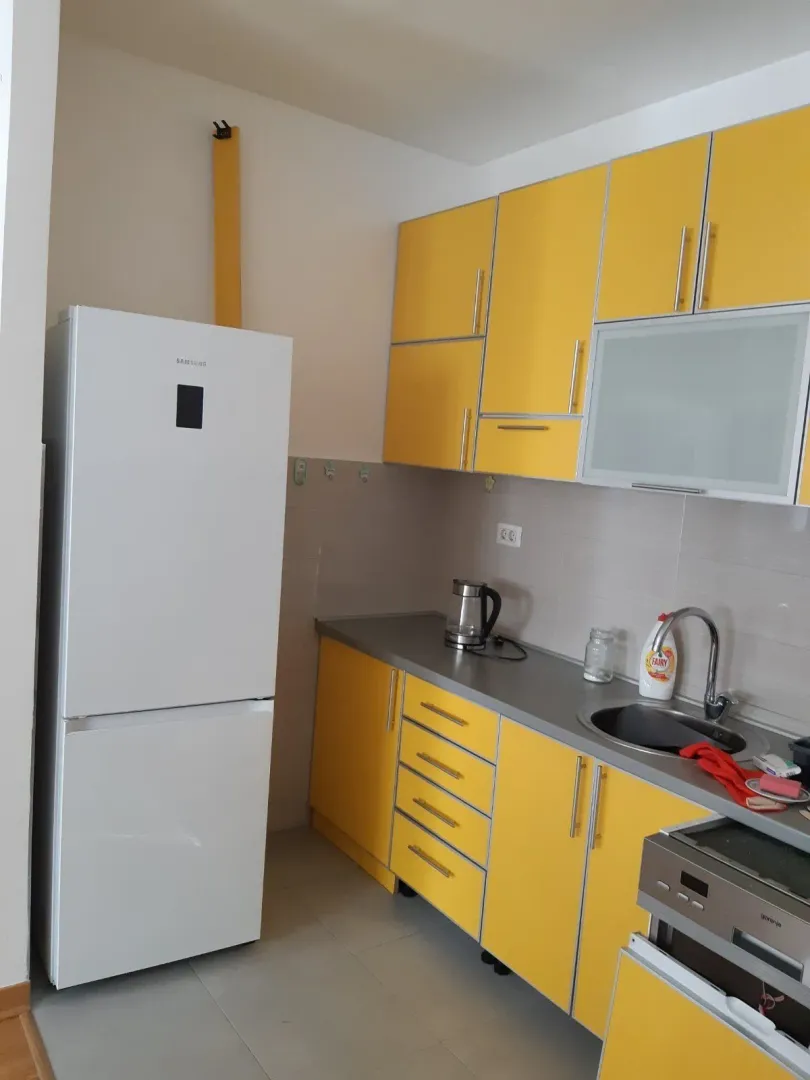 Bright kitchen with yellow cabinets and a white refrigerator.