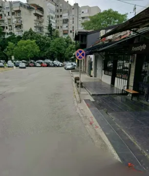 View of the street and the exterior of the building with a parking lot in the background. - image 9