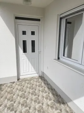 Ulaz u kuću sa bijelim PVC vratima i popločanim podom. - image 9
