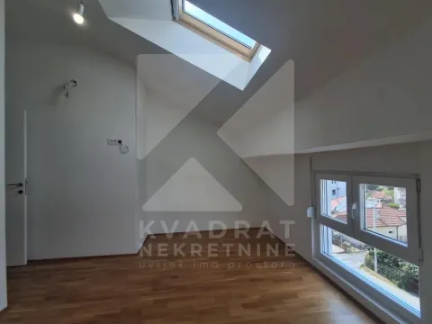 Empty attic room with a skylight and laminate flooring. - image 15
