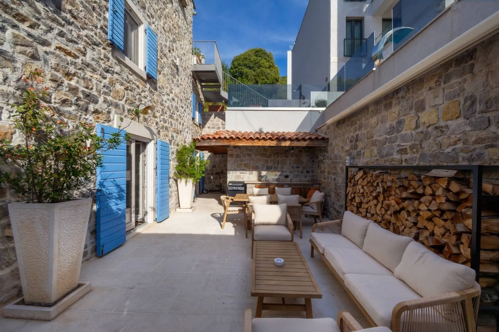 Paved courtyard with outdoor seating furniture and stone walls.
