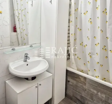 Small bathroom with a sink, mirror, and bathtub with a curtain. - image 13