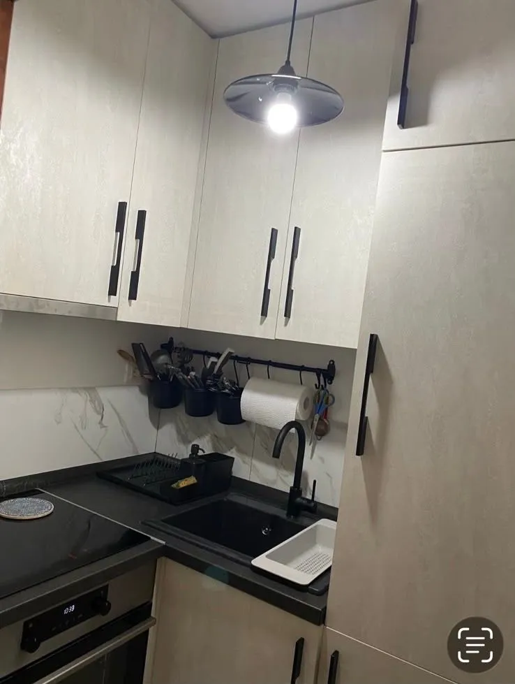 View of a section of a modern kitchen with cabinetry and a sink.