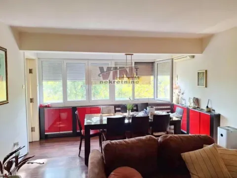 Spacious living room with a dining table and large windows. - image 2