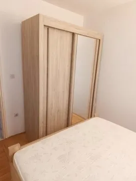 Spavaća soba sa krevetom i drvenim ormarom sa ogledalom. - image 11