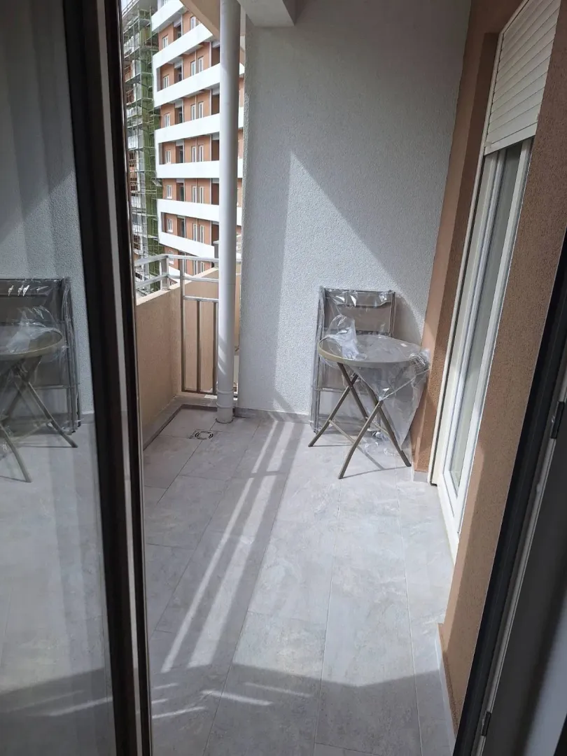 Balkon sa pločicama i pogledom na susjedne zgrade.