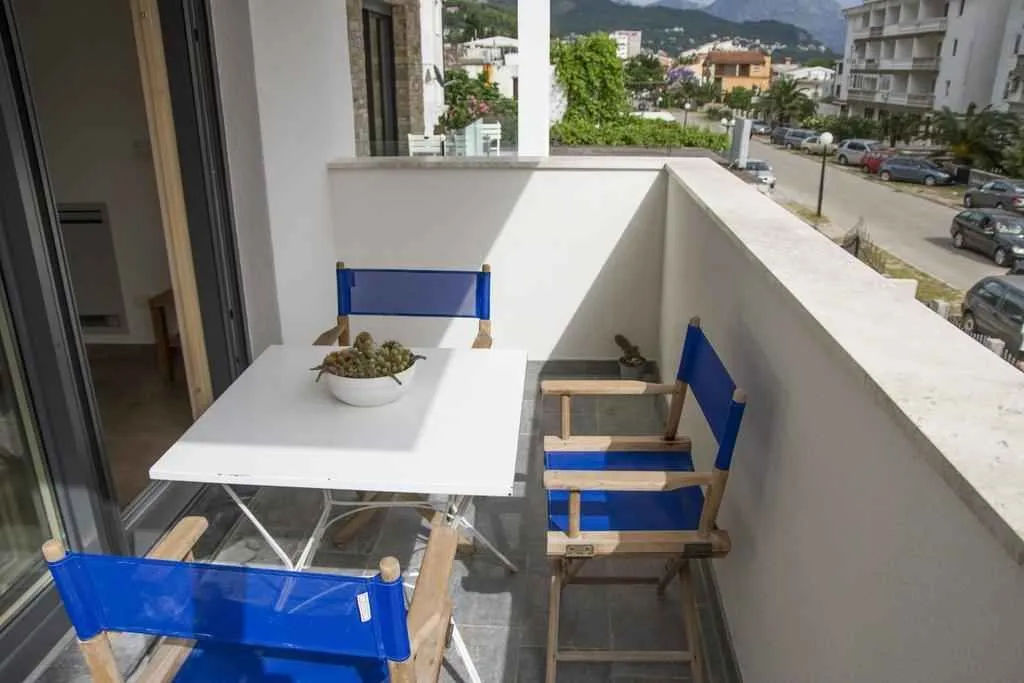 Balkon sa stolom i plavim stolicama.