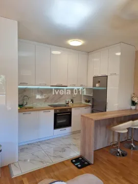 Moderna bela kuhinja sa šankom i ugradnim aparatima. - image 3