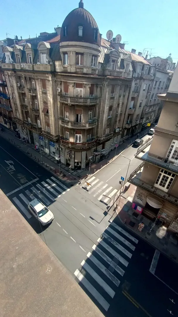 Pogled sa prozora na gradsku ulicu i okolne zgrade.