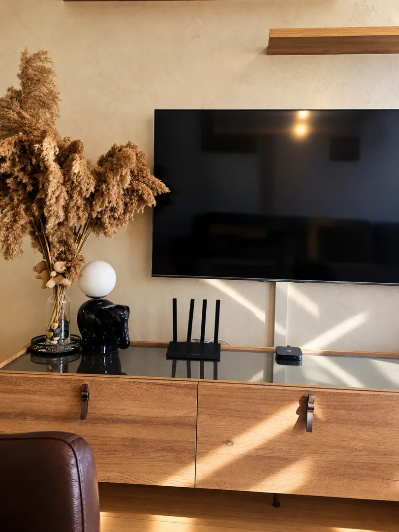 Living room with a wooden chest of drawers, TV, and decorative details.