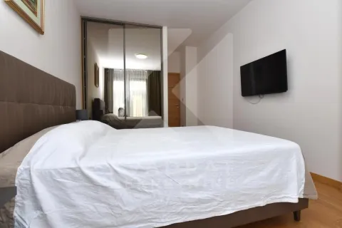 Bedroom with a double bed, mirrored wardrobe, and wall-mounted TV. - image 7