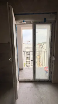 Pogled kroz balkonska vrata na terasu i okolne zgrade. - image 8