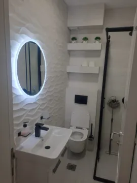 A modern bathroom equipped with a sink, toilet, and walk-in shower. - image 10