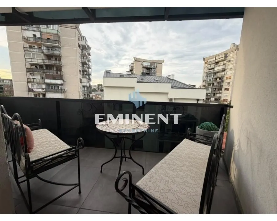 Namješten balkon sa garniturom za sjedenje i pogledom na grad.