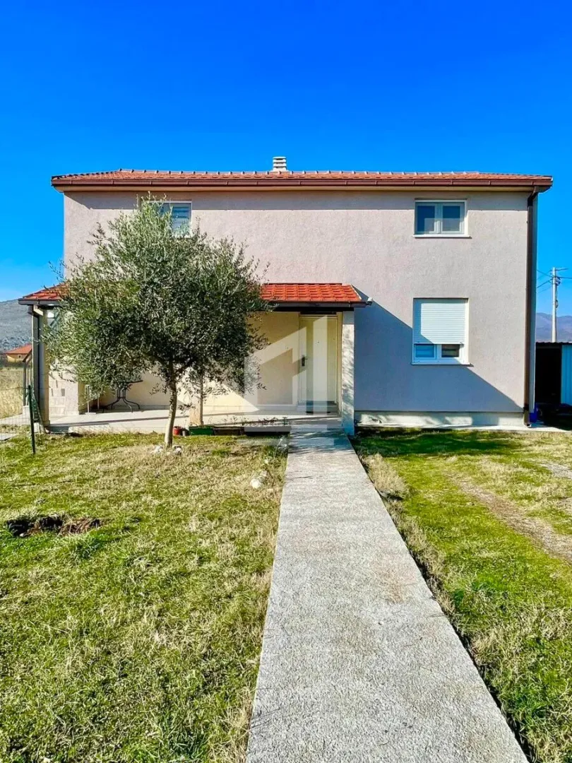 View of the yard and the front facade of the house with a walkway.