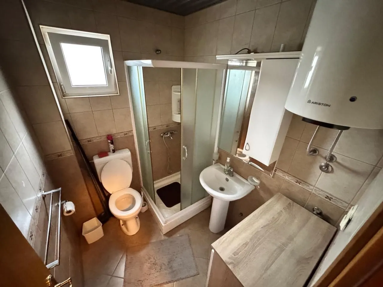 Manje kupatilo sa tuš kabinom, umivaonikom i wc šoljom.